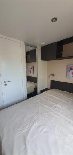 - une chambre avec un grand lit blanc dans l'établissement mobil-home grand confort spa camping hyères, à Hyères