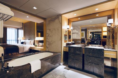 a bathroom with a large tub and a bed at The Azure Ningbo, Vignette Collection in Ningbo