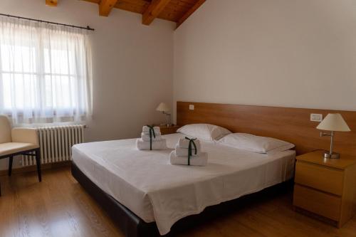 a bedroom with a bed with two boxes on it at Elliot Osteria e dormire in collina in Manzano