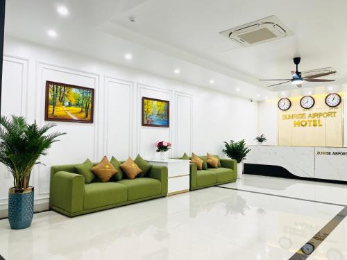 a living room with two green couches and a fireplace at Sunrise Airport Hotel - Noi Bai Airport in Thach Loi