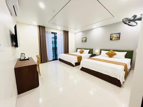 a hotel room with two beds and a television at Sunrise Airport Hotel - Noi Bai Airport in Thach Loi