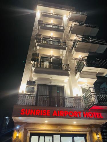 a tall white building with a red sign on it at Sunrise Airport Hotel - Noi Bai Airport in Thach Loi