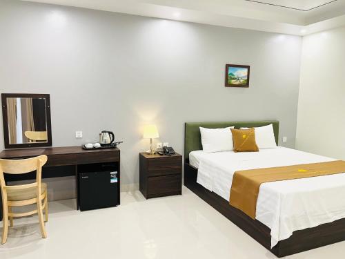 a bedroom with a bed and a desk with a mirror at Sunrise Airport Hotel - Noi Bai Airport in Thach Loi