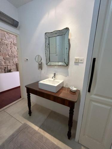 a bathroom with a sink and a mirror on the wall at Bed & Breakfast The Konoba in Šibenik