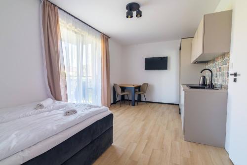 a bedroom with a bed and a kitchen with a table at Willa Kwidziński in Władysławowo