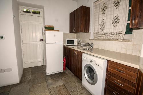 a kitchen with a white refrigerator and a washing machine at Anastou's Traditional House in Kalopanayiotis