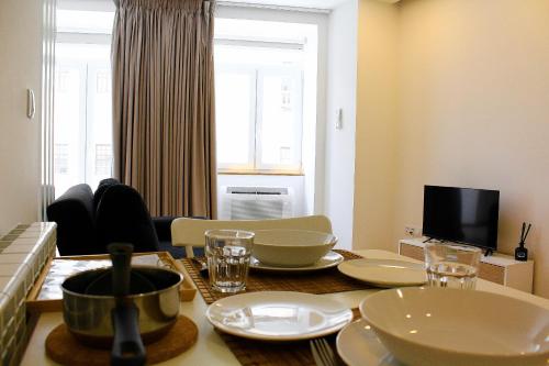 a living room with a table with dishes on it at Apartamentos Avenida Premium in Vila Real
