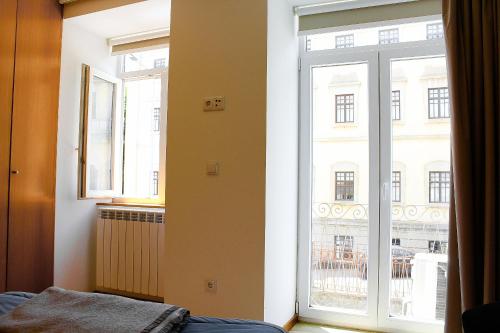 a bedroom with a large window with a view of a building at Apartamentos Avenida Premium in Vila Real
