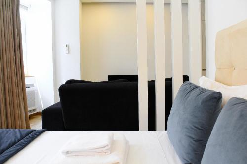a bedroom with a bed and a black couch at Apartamentos Avenida Premium in Vila Real