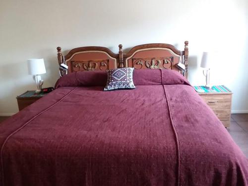 a bed with a purple blanket and a pillow on it at Comfortable Generously Furnished Home in Sierra Vista