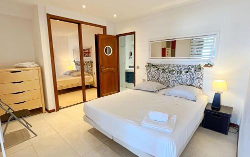 une chambre avec un grand lit blanc et un miroir dans l'établissement ACCI Cannes Marina, à Cannes