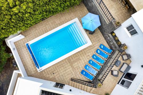 an overhead view of a pool and chairs and an umbrella at Casa El Paraiso - Private Pool, Jacuzzi, Air-con and BBQ By Lanzarote Vacation Homes in Tías