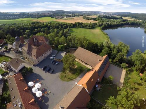 an aerial view of a building next to a lake at Schlossgut Franken - Schlossapartment Martin in Redwitz an der Rodach