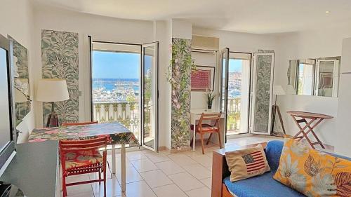 - un salon avec un canapé bleu et quelques fenêtres dans l'établissement ACCI Cannes Marina, à Cannes