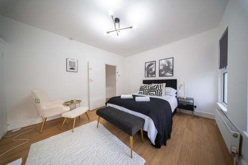 a bedroom with a bed and a chair in it at The Hampden House - Sleeps 7 in Grays Thurrock