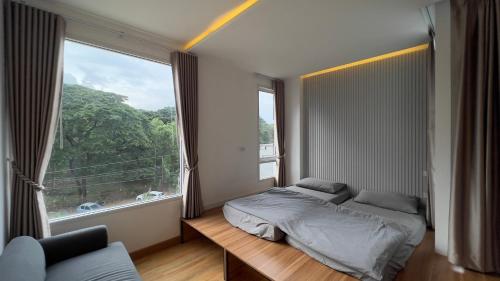 Un dormitorio con una cama y una ventana grande. en Calm and Green Place, en Chiang Mai