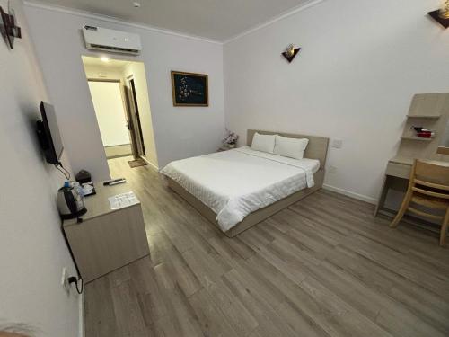 a bedroom with a bed and a table and a television at Sài Gòn - Hà Tiên in Ha Tien