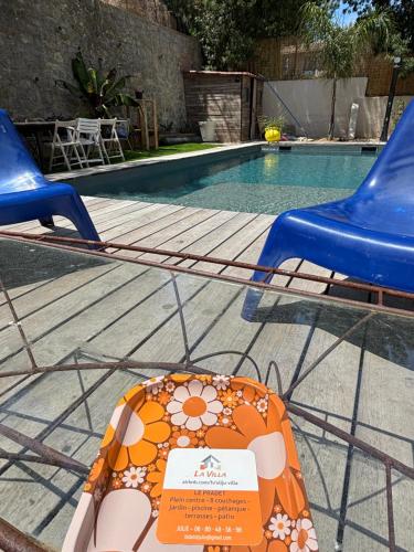 - une table avec deux chaises à côté de la piscine dans l'établissement LA VILLA, au Pradet