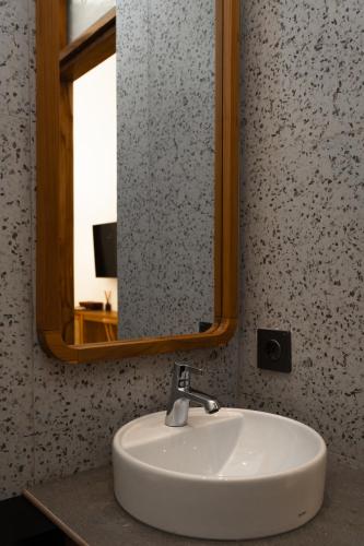 a white sink in a bathroom with a mirror at Green Hill Boutique Hotel in Labuan Bajo