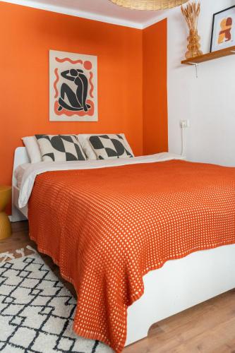 a bedroom with an orange wall and a bed at Dotan's Boutique Studios - By The Beach! in Tel Aviv