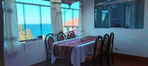 a dining room with a table and chairs with a view of the ocean at LA MANSION DEL SOL LODGE Taquile island in Isla Taquili