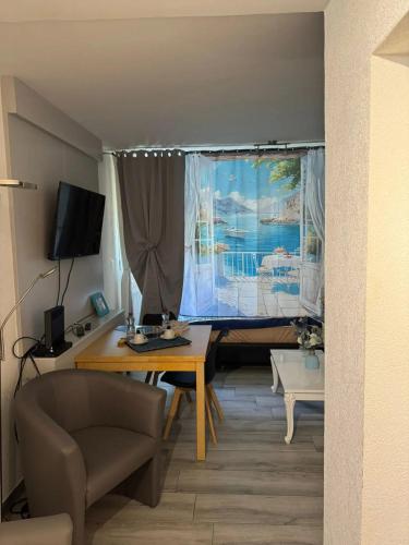 a living room with a table and a window at Comfortable studio in Bevaix with mountain view - 30 m² + Spa in Bevaix