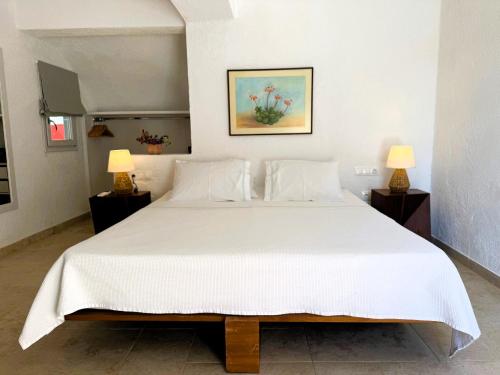 a bedroom with a large white bed with two lamps at Golden Sun Hotel Patmos in Patmos