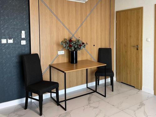 a table with two chairs and a vase of flowers on it at Hotel Lantier Wellness & Spa in Bytom