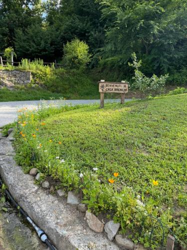 a sign on the side of a road with flowers at Casa Brencio in Masera