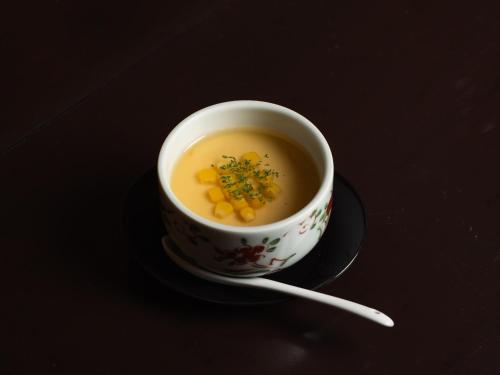 a cup of soup on a plate with a spoon at 小樽旅亭 蔵群 in Otaru
