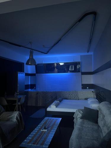 a blue room with a bed and a couch at Ευρύχωρος χώρος φιλοξενίας in Xanthi