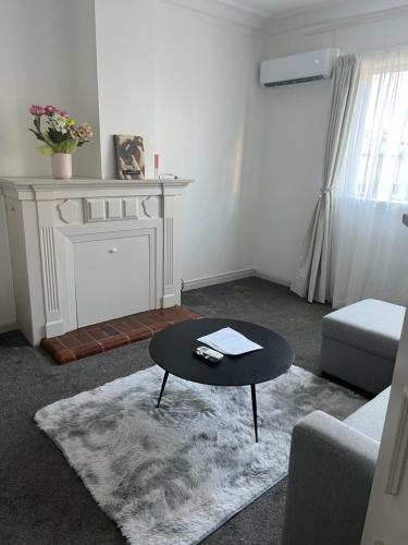 a living room with a coffee table and a fireplace at Sun-kissed house in Auckland