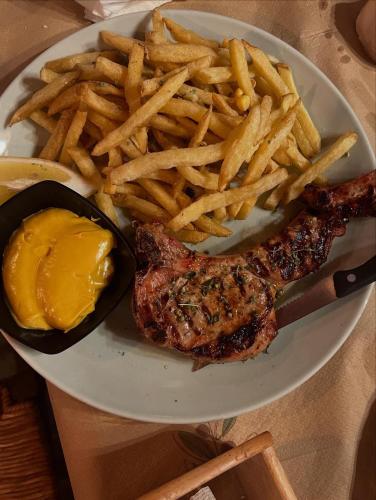 a plate of food with a steak and french fries at Famprika Volissos in Chios
