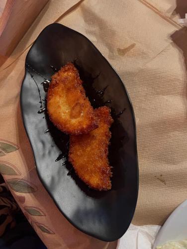a black plate with a piece of food on it at Famprika Volissos in Chios