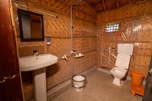 a bathroom with a sink and a toilet at Hampi Natures Cottage in New Hampi