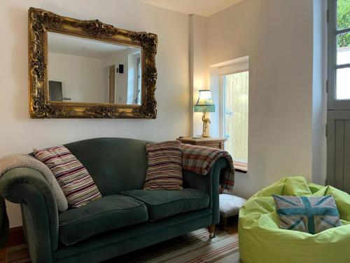 a living room with a green couch and a mirror at Jack's House in Hastings