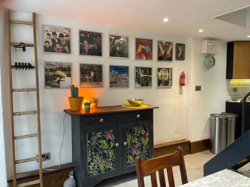 a kitchen with a black cabinet and pictures on the wall at Jack's House in Hastings