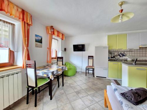 a kitchen and dining room with a table and a refrigerator at Apartma Vučič in Bovec