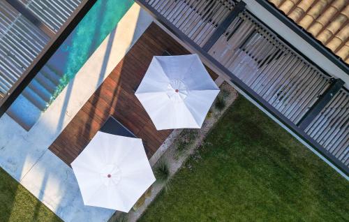 an overhead view of two white umbrellas on the grass at Villa Silente in Bale