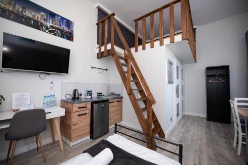 a room with a staircase and a desk and a kitchen at City Place Noclegi in Wrocław