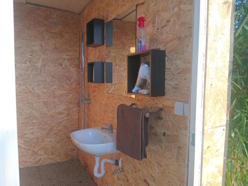 a bathroom with a sink and a tv on a wall at Tenda campismo 47 A Retiro dos sonhos in Lagoa