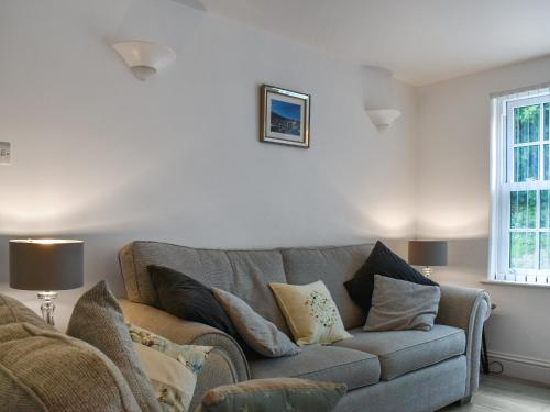 a living room with a gray couch with pillows at Harbour Reach in Mevagissey