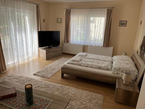 a bedroom with a bed and a flat screen tv at Gold Apartmann Hévíz in Hévíz
