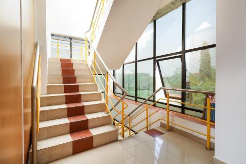 a staircase in a building withwindows and a stair case at Super Hotel O Rj Tower in Madurai