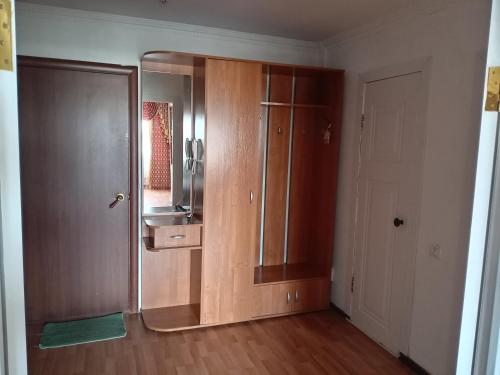 eine Küche mit Edelstahlkühlschrank und Holzschränken in der Unterkunft Кенесары Жубанова in Astana