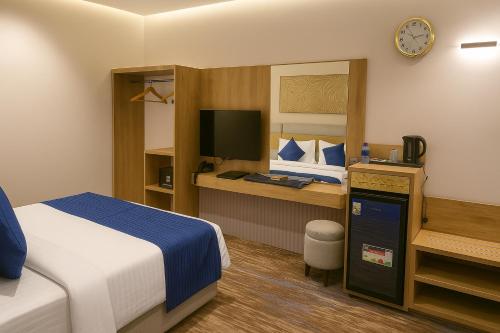 a hotel room with a bed and a tv at Elite Served Apartments - Al Cornich in Jeddah