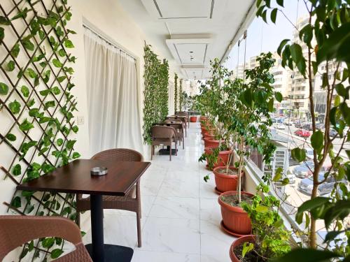 a corridor with tables and potted plants in a restaurant at Afnan Cairo Airport in Cairo