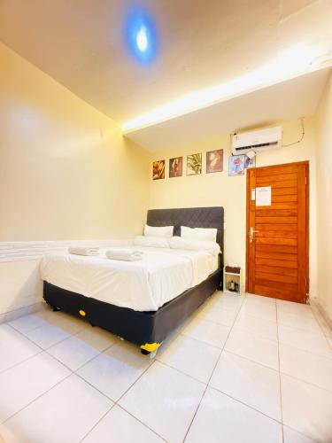 Un dormitorio con una cama grande en una habitación. en Homestay Room near Kuta & Legian Beach Bali, en Pesanggaran