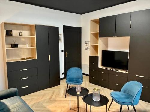 a living room with two blue chairs and a tv at Coeur De Plage - Studio Royan Hyper Centre - Classé 3 étoiles - 2 pers - 150m plage in Royan