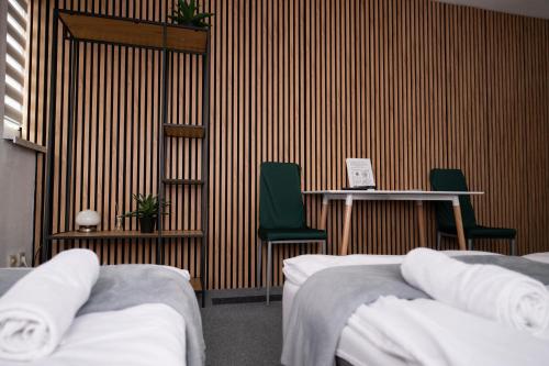 a room with two beds and two tables and chairs at City Place Noclegi in Wrocław